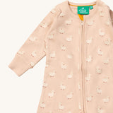 A close up of the Little Green Radicals puddle ducks baby grow, showing the full length zip detail on link pink organic cotton fabric.
