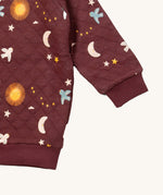 A close up of the Little Green Radicals flying birds quilted sweatshirt that's available at Babipur. Showing the quilted detail on dark maroon organic cotton fabric