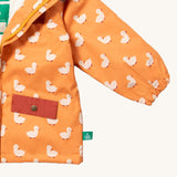 A close up of the Little Green Radicals waterproof coat in gold ducks showing the elasticated cuff detail on yellow recycled polyester fabric