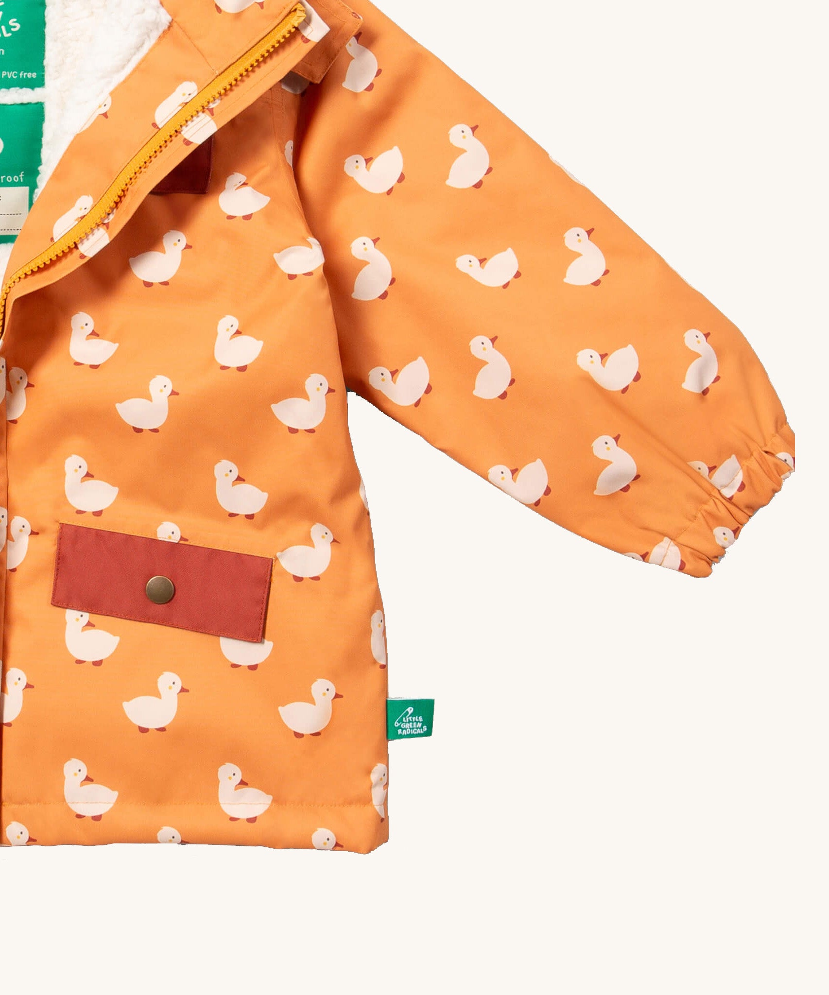A close up of the Little Green Radicals waterproof coat in gold ducks showing the elasticated cuff detail on yellow recycled polyester fabric