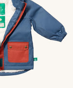 A close up of the Little Green Radicals waterproof coat in moonlight blue Showing the elasticated cuff detail on blue recycled polyester fabric