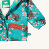 A close up of the Little Green Radicals waterproof coat in winter rabbits showing the sherpa fleece inner liner and full length zip detail on turquoise recycled polyester fabric