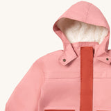 A close up of the Little Green Radicals waterproof coat in coral showing the sherpa fleece liner, the full length zip and 2 side pockets in dark pink trim detail on pink recycled polyester fabric