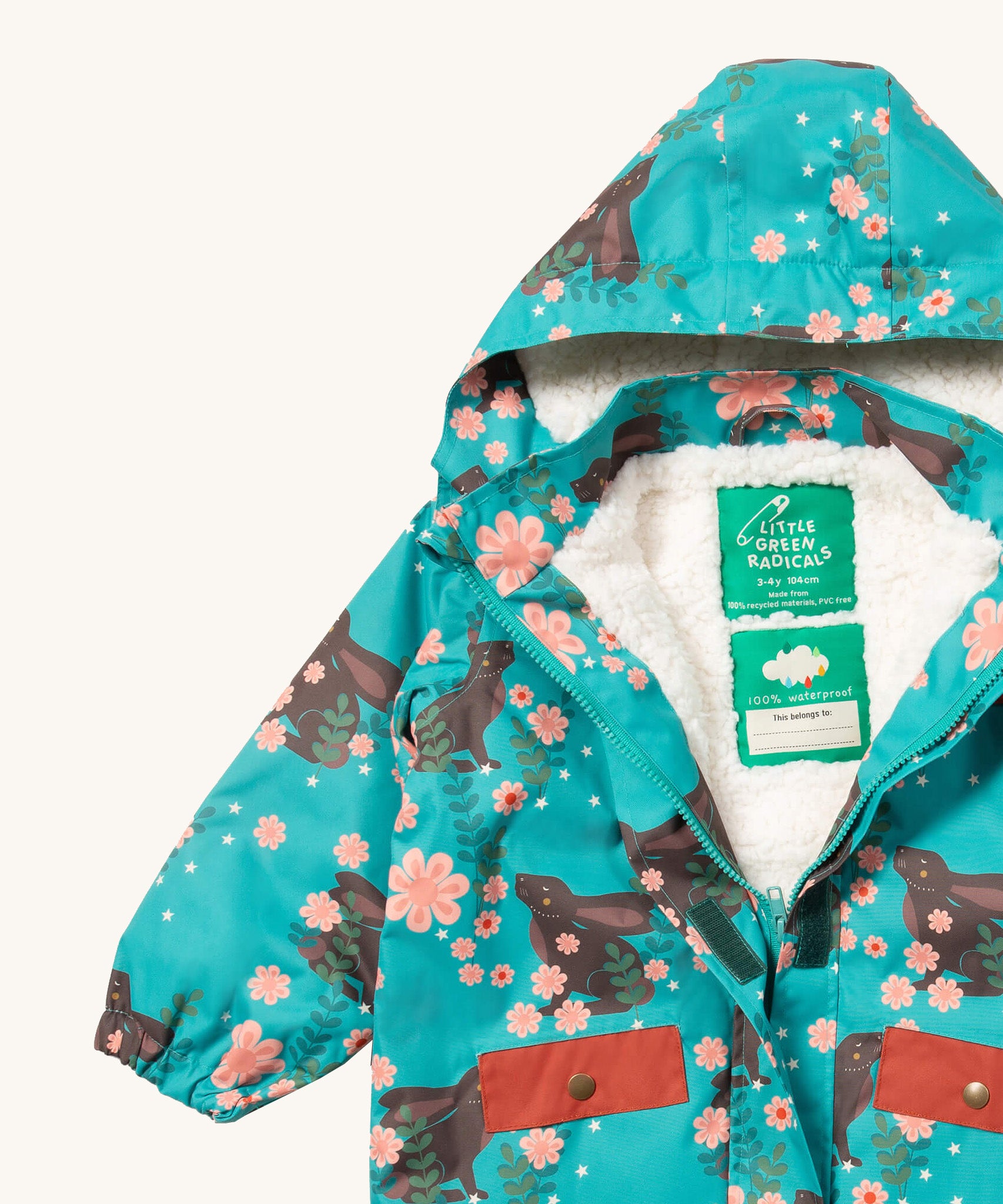 A close up of the Little Green Radicals waterproof coat in winter rabbits showing the hood detail with sherpa fleece liner and name patch detail on turquoise recycled polyester fabric
