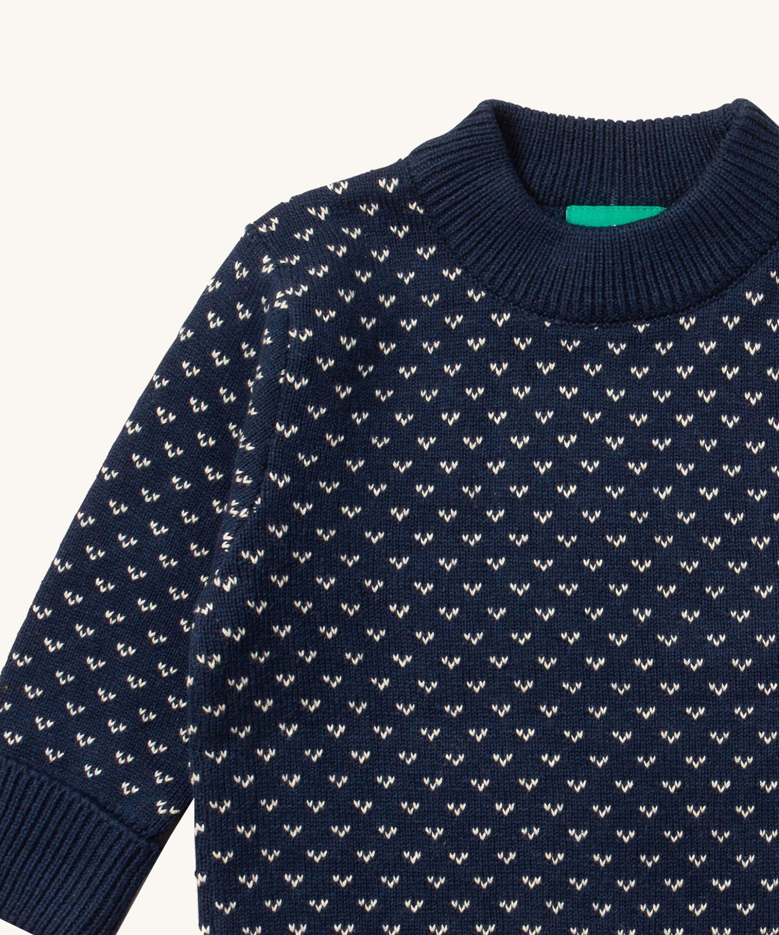A close up of the Little Green Radicals navy sheep design showing the thick navy cuff and hem detail and a close up of the white speckles on navy organic cotton fabric