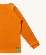 A close up of LGR Long Sleeve Waffle Top - Golden Ochre showing the waffle texture detail on yellow organic cotton fabric