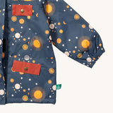 A close up of the Little Green Radicals waterproof coat in night moon. Showing the elasticated cuff detail and red side and chest pocket detail on navy recycled polyester fabric