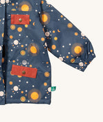 A close up of the Little Green Radicals waterproof coat in night moon. Showing the elasticated cuff detail and red side and chest pocket detail on navy recycled polyester fabric