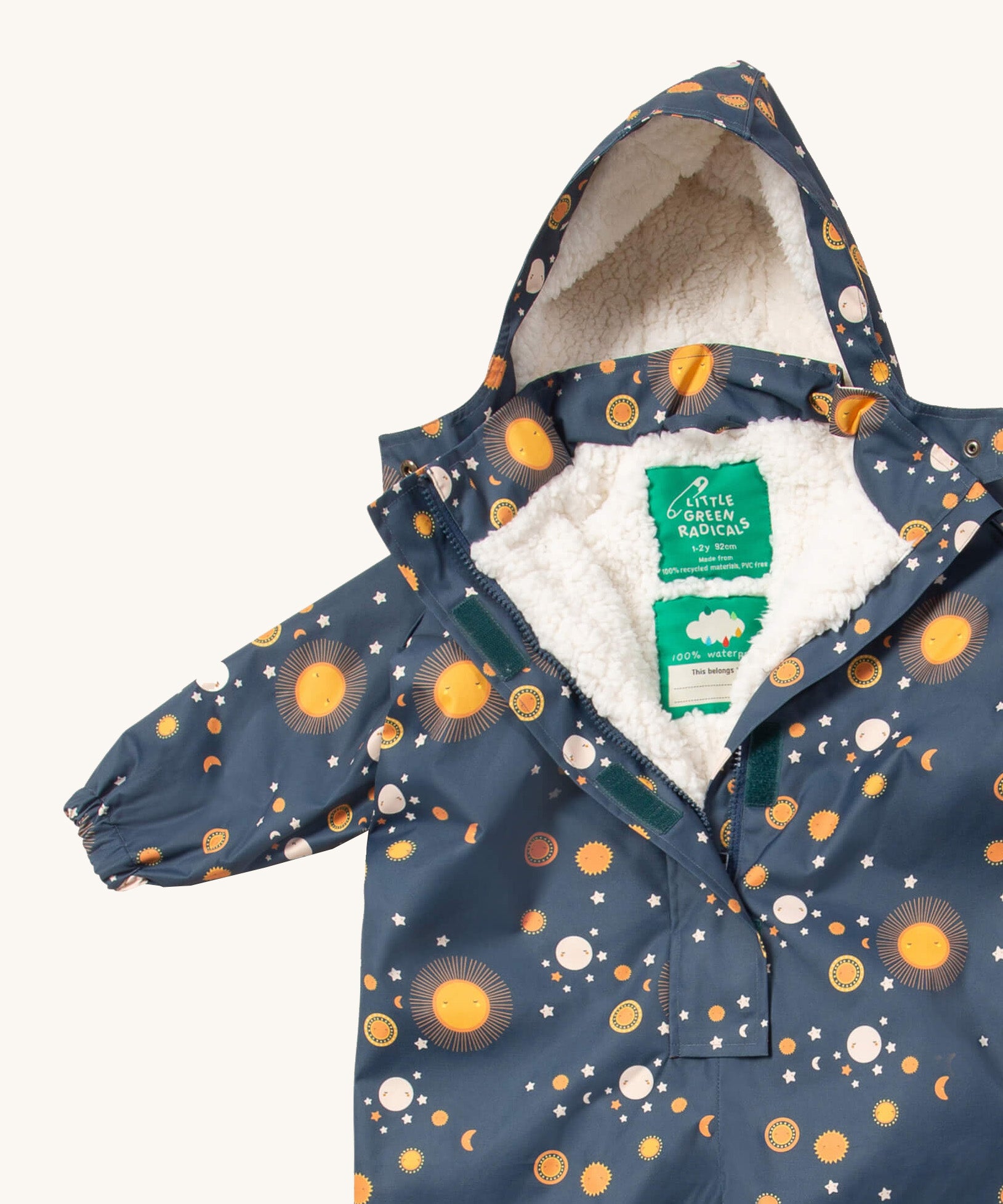 A close up of the Little Green Radicals night moon waterproof winter suit. Showing the sherpa fleece inner liner detail under the hood and 1/2 length zip detail and name patch stitched on the inside on navy recycled polyester fabric.