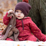 A baby wearing the Little Green Radicals Organic Cotton Quilted Snug Suit with a Red Stars design. This snug suit is a part of a wide range of organic cotton clothing for children available here at Babipur.