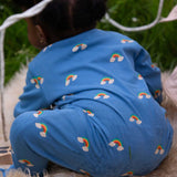 A baby wearing the Little Green Radicals Blue Rainbows Zip Organic Babygrow. The baby is facing away from the camera. Little green Radicals have a wide range of organic cotton, Fairtrade clothing and outerwear for babies and children available here at Babipur.
