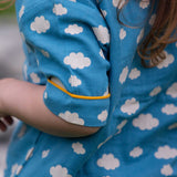 A close up of the short sleeve on the top from the Little Green Radicals Blue Clouds Button Through Pyjama Short Set. The set contains a traditional style, short sleeved shirt style top with matching shorts. The print has a blue background with an over white cloud print. Little green Radicals have a wide range of organic cotton, Fairtrade children's clothing and outerwear available here at Babipur.