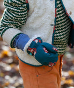 A close up of a child's hand, the child is wearing the Little Green Radicals fox print sherpa fleece lined mittens. The children's sized mittens are part of a wide range of organic cotton clothing for children available here at Babipur.