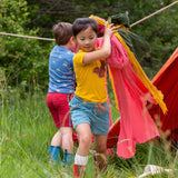 A child wearing the Little Green Radicals Yellow gold coloured Squirrel t-shirt with blue striped shorts.