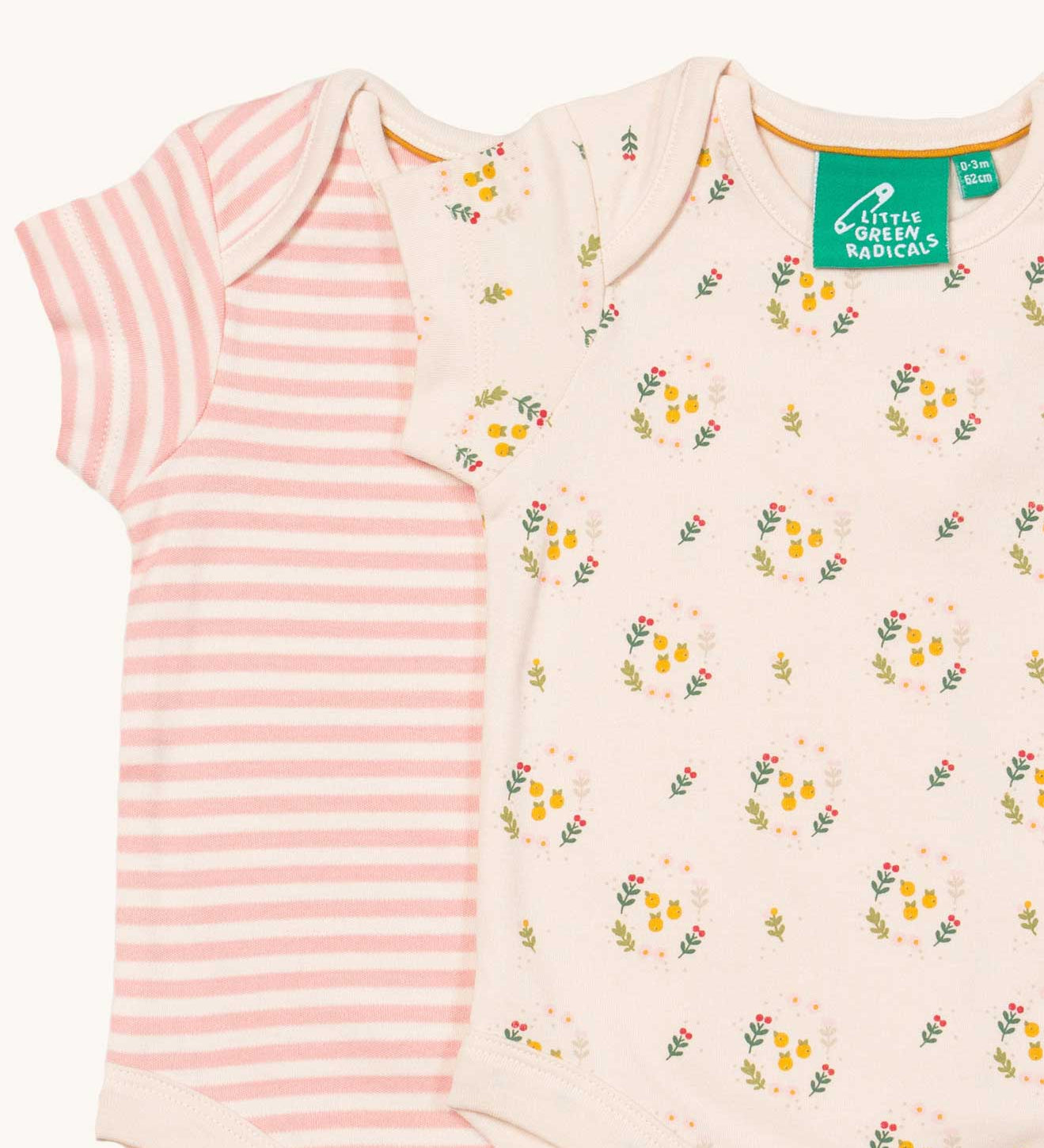 A close up of the 2 pack of Little Green Radicals Quince Flowers Baby Body Set. One vest has a pink and white stripe with the other vest featuring an all over quince flower print. These short sleeved baby best are part of a wide range of organic cotton baby clothes available at Babipur.