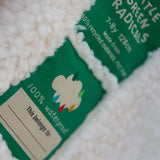 Two little green radicals labels on a white textured surface, with one label partially obscured.