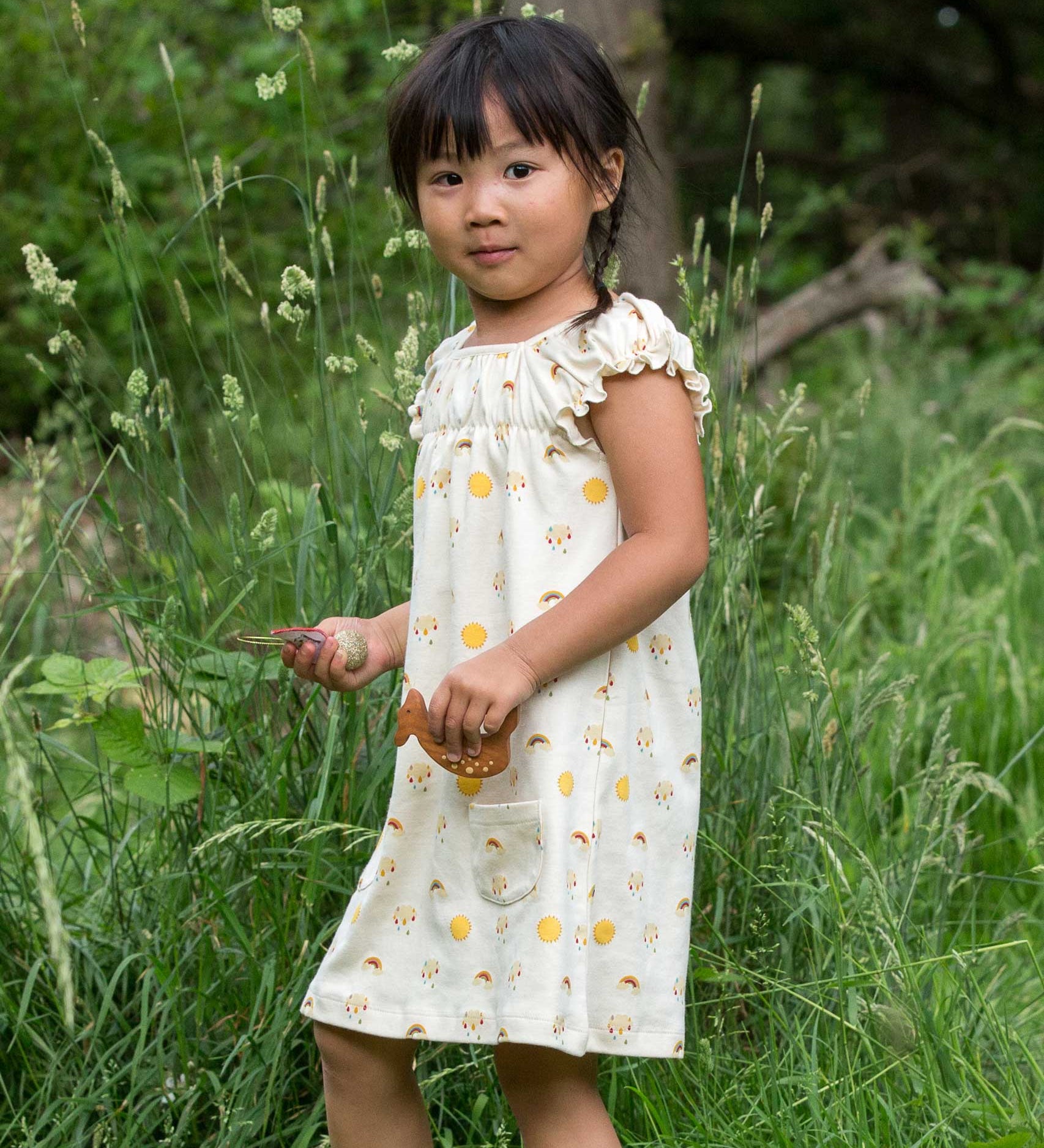A child wearing the Little Green Radicals Sunshine & Rainbows Pocket Playdays Dress. Little green Radicals have a wide range of organic cotton, Fairtrade children's clothing and outerwear available here at Babipur.