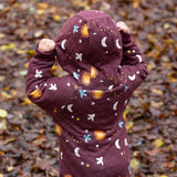A child wearing the Little Green Radicals Organic Cotton Flying Birds Quilted Snug Suit. The child is facing away from the camera and is wearing the hood up.
A maroon brown coloured suit with an all over print featuring flying birds, stars, moon and  sun. This snug suit is a part of a wide range of organic cotton clothing for children available here at Babipur.