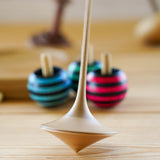 Mader hand carved ballerina spinning top toy on a wooden background