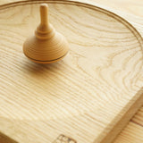 Mader kids classic wooden spinning top toy on a wooden Mader spinning top plate