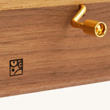 A closeup of the Mader music box handle, and the engraved logo.