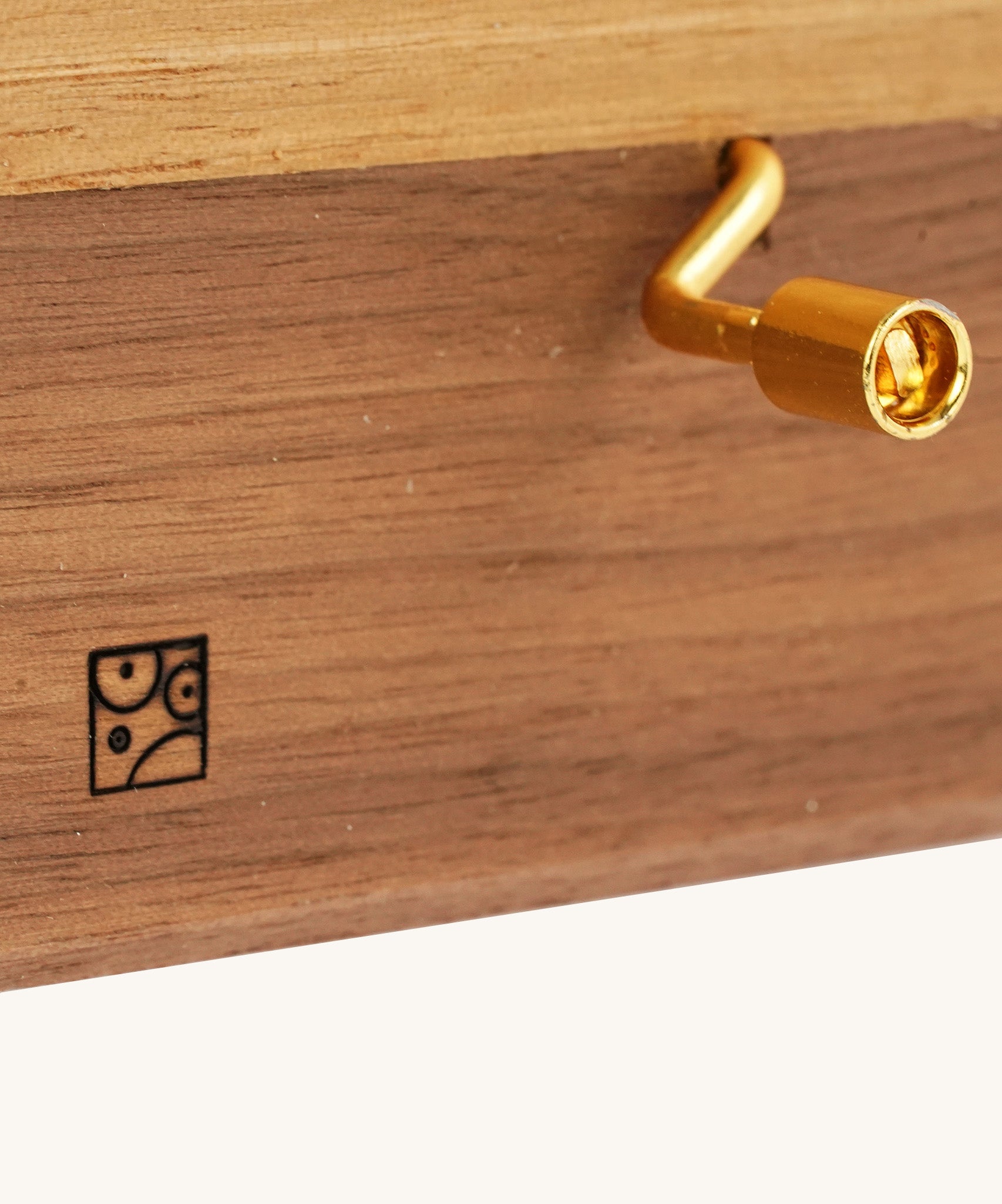 A closeup of the Mader music box handle, and the engraved logo.