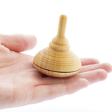 Close up of a Mader handmade classic wooden spinning top toy in the palm of a hand