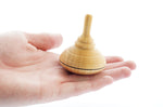 Close up of a Mader handmade classic wooden spinning top toy in the palm of a hand
