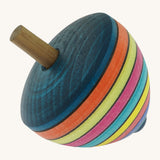 A wooden Mader dragon egg spinning top with multicoloured stripes on a cream background