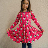 A child wearing the Maxomorra Fairy print circle dress. The child is holding up the sides of the skirt to show the shape.