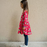 A child wearing the Maxomorra Fairy print circle dress. The child is facing the side showing the side of the dress.