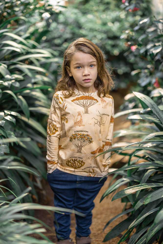 giraffes and tree names repeat print. Worn by child with long hair