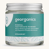A jar of the spearmint Georganics toothpaste powder on a cream background