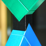 Angular construction toy from Naef arranged in a complex geometric stack in front of a white background.