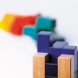 Close up of the blocks from the Naef premium campanile shape sorting puzzle toy lined up on a white background