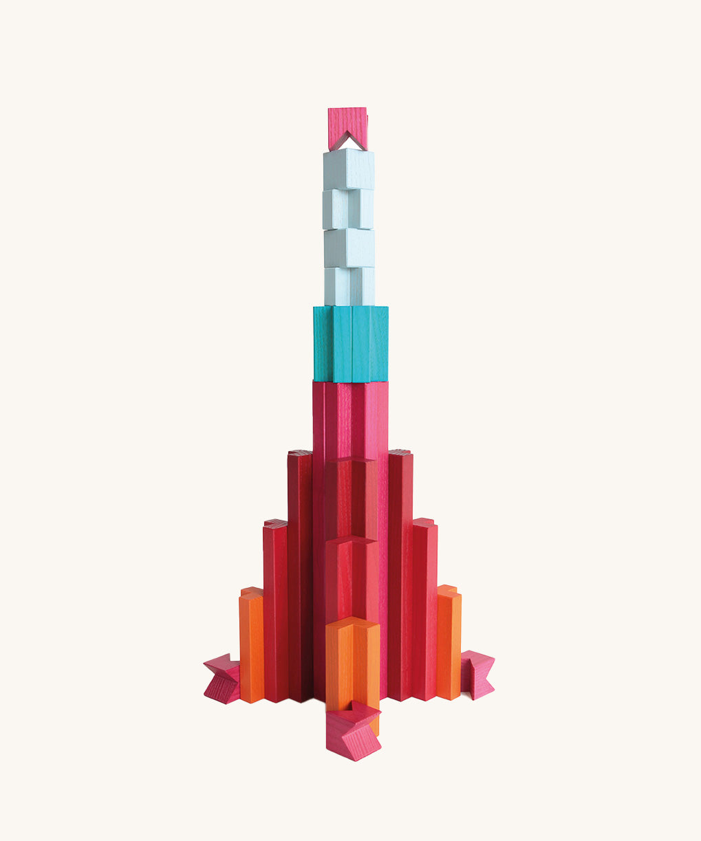 Rocket-shaped structure built from Naef Tigno coloured wooden pieces. Handcrafted precision German made stacking game and architectural desk toy.
