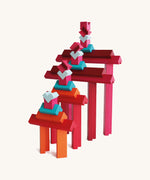 Layered tower of Naef Tigno coloured wooden blocks in varying lengths and hues. High quality German made precision wooden toy for stacking and display.