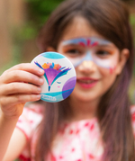A girl looking at her face paint with the compact mirror from the Namaki non-toxic children's makeup Gift Set