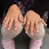 A closes up of a child's hands, with painted nails using the Namaki non-toxic child-safe nail varnish from the makeup gift set.