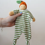 A Nanchen Orange Baby Comforter Doll being held up in an adult's hand.
