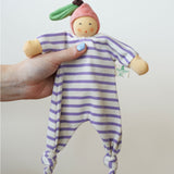 A Nanchen peach Baby Comforter Doll being held up in an adult's hand.