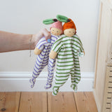 Nanchen peach and orange Baby Comforter Dolls being held up in an adult's hand.