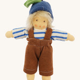 Front view of the Nanchen organic Waldorf doll Bela Blueberry, fully dressed in a blue and white striped long-sleeve top, brown dungarees, and a blue woollen fruit-style hat with a green leaf detail. The doll has soft blond hair and a gentle hand-painted expression.