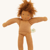 Full view of the same Nanchen organic Waldorf doll with brown skin and tousled brown hair, shown unclothed to highlight the soft fabric body.