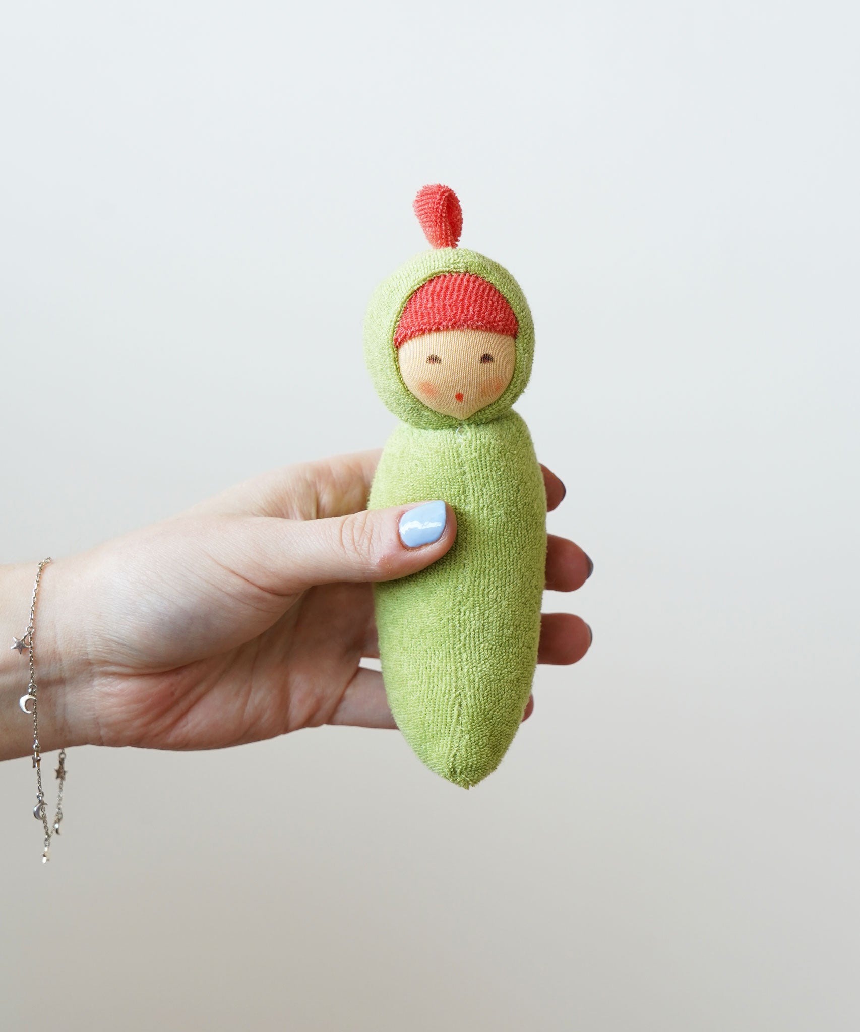 Nanchen Peapod Baby Rattle Doll being held in an adult's hand.