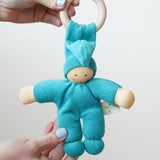 A turquoise coloured Nanchen Pimpel Waldorf Doll Ring Comforter in an adult's hands.