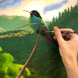 An artist painting a landscape photo with bird perched on a twig using the Natural Earth Paint natural acrylic paints