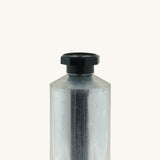 A close up of the blank flexible aluminium tube from Natural Earth Paint showing the detail of the black screw cap