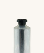 A close up of the blank flexible aluminium tube from Natural Earth Paint showing the detail of the black screw cap