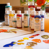 Natural Earth Paint acrylic set on a wooden surface with samples on a paper